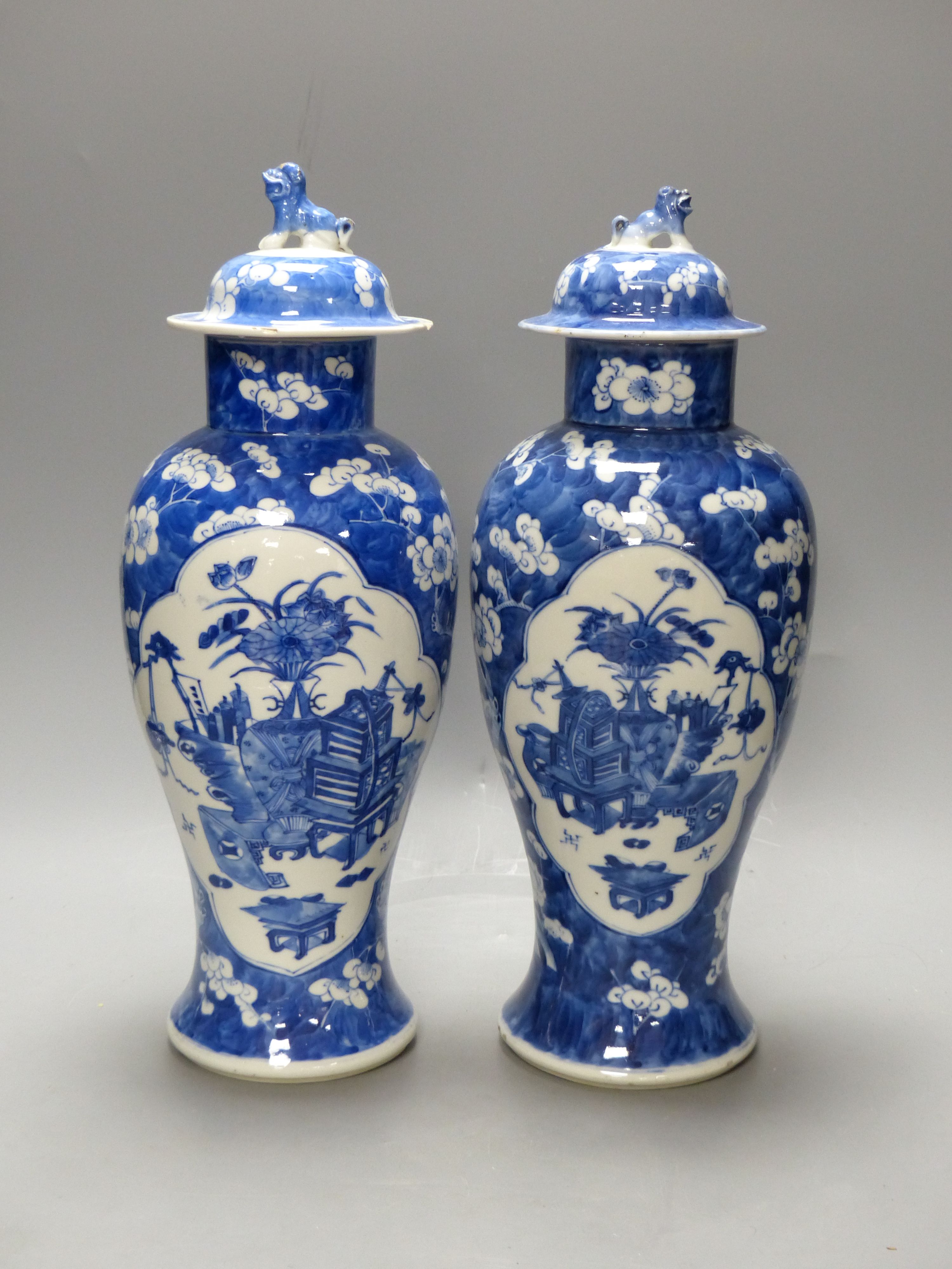 A pair of 19th century Chinese blue and white prunus vases and covers, height 38cm, a Kangxi marks